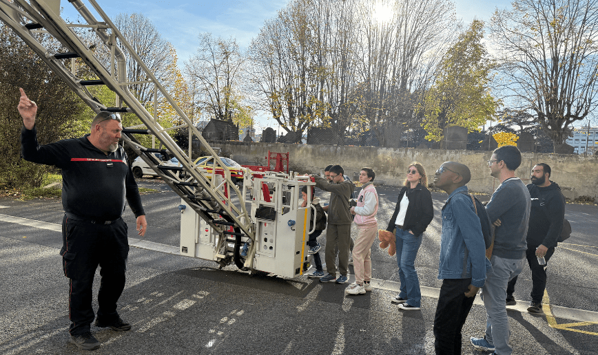 enfants devants la nacelle de l'échelle d'un camion des sapeurs-pompiers du Puy-de-Dôme