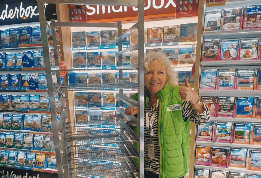 Dans un magasin Intermarché. 1 personnes de l'association montre avec satisfaction, le pouce en l'air un chariot de brioche vide. Succès de la vente.