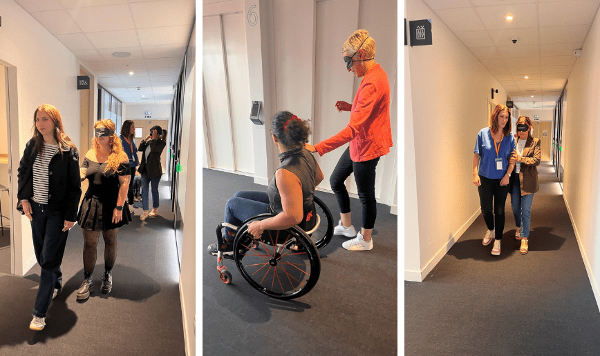 Guidage au bras : binôme de deux personnes dans les couloirs du PIC qui apprennent à guider une personne en situation de handicap visuel.